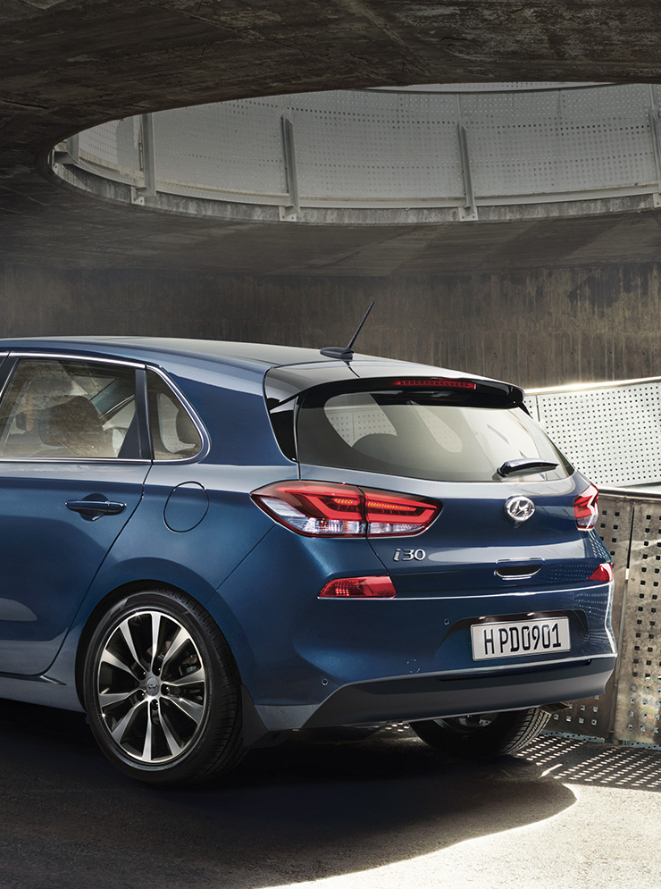 Left side rear view of blue i30 on the uphill road