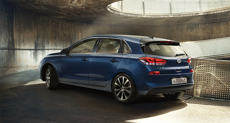 Left side rear view of blue i30 driving on the uphill road